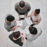 Above shot of a group of businesspeople standing together and discussing strategies at work.